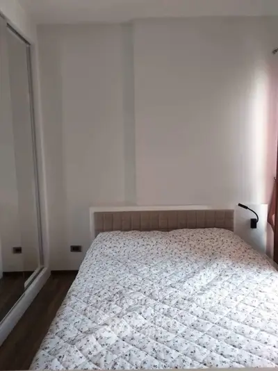 Cozy bedroom with mirrored wardrobe and soft lighting