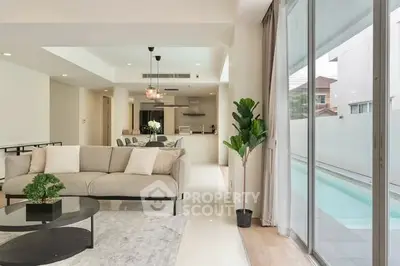 Luxurious open-plan living room with pool view and modern decor