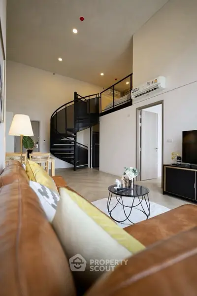 Modern loft-style living room with spiral staircase and cozy seating area.