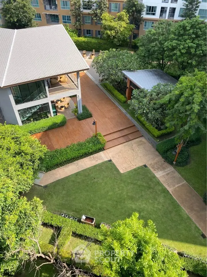 Stunning aerial view of modern residential complex with lush gardens and outdoor seating area.
