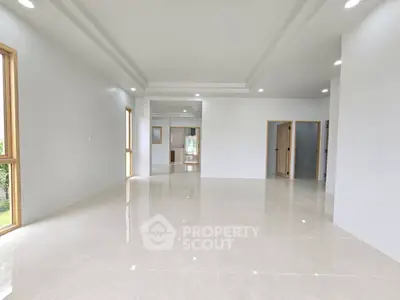 Spacious modern living room with glossy tiled floors and large windows for natural light.
