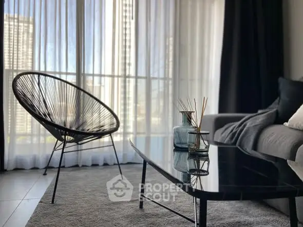 Stylish modern living room with floor-to-ceiling windows and chic furniture.