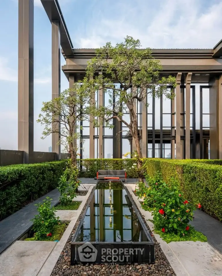 Luxurious rooftop garden with serene water feature and lush greenery in modern building.