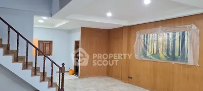 Spacious living room with wooden accents and staircase, perfect for modern living.