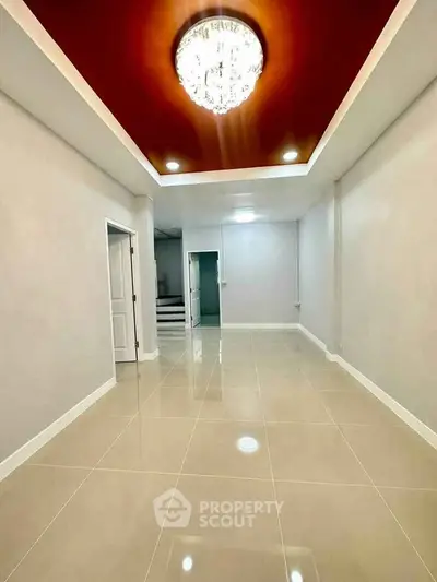 Spacious modern interior with elegant chandelier and glossy tiled flooring