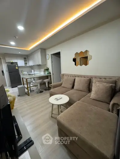 Modern living room with cozy sofa and open kitchen layout, perfect for urban living.