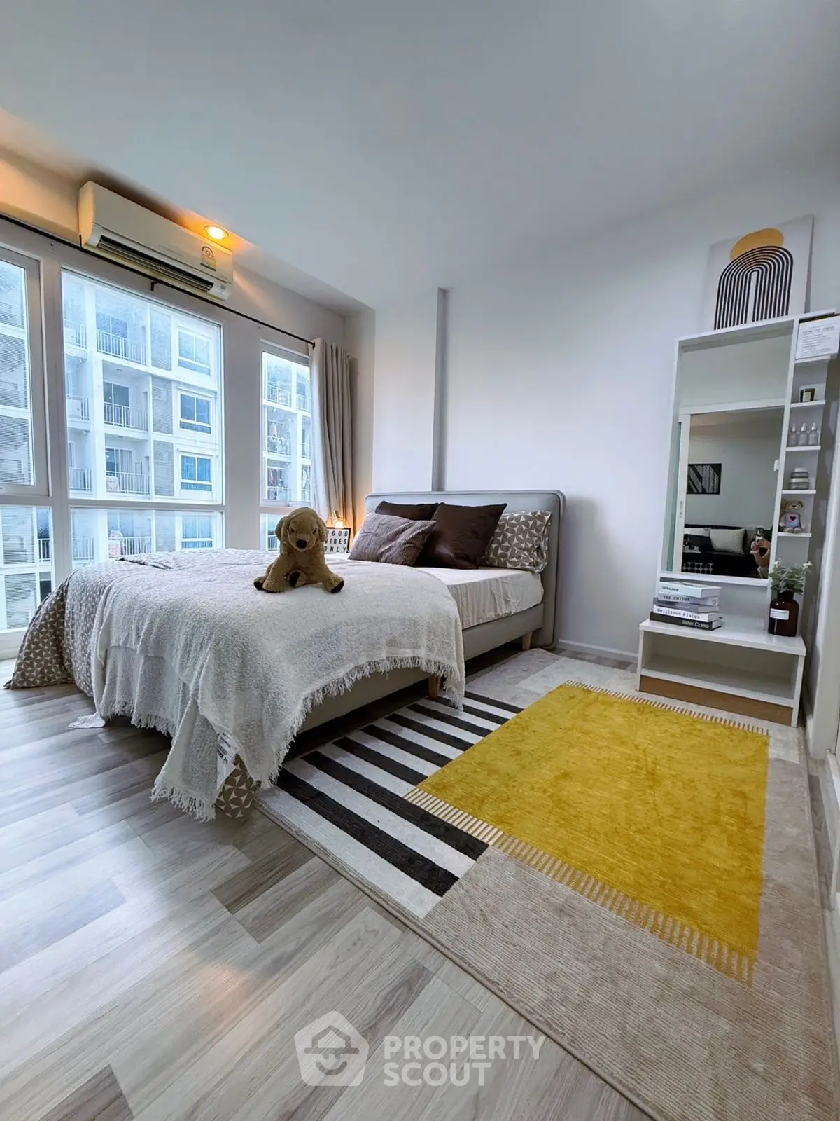 Modern bedroom with stylish decor and large windows in a contemporary apartment.