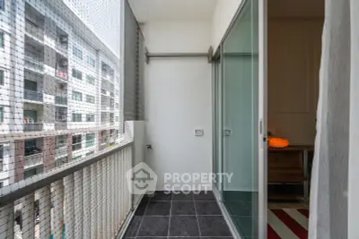 Modern apartment balcony with sliding glass doors and tiled flooring