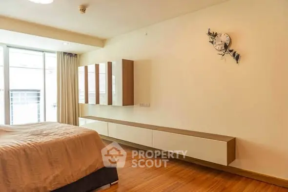 Spacious modern bedroom with wooden flooring and minimalist decor