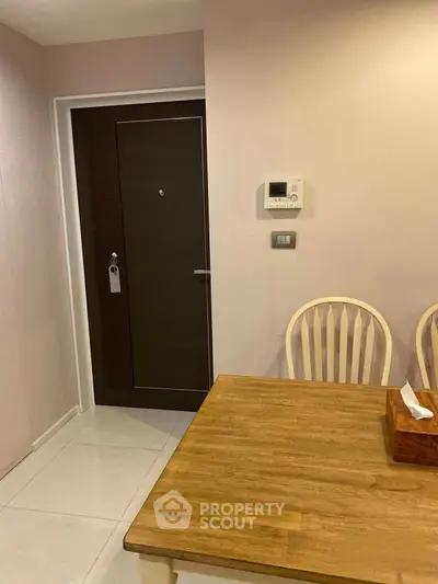 Cozy dining area with wooden table and chairs near entrance door