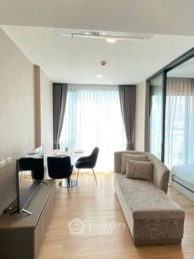 Modern living room with stylish furniture and large windows offering natural light in a contemporary apartment.