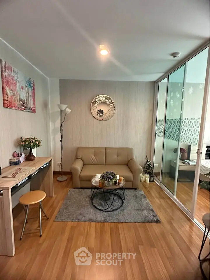 Cozy living room with modern decor and wooden flooring, featuring a comfortable sofa and stylish coffee table.