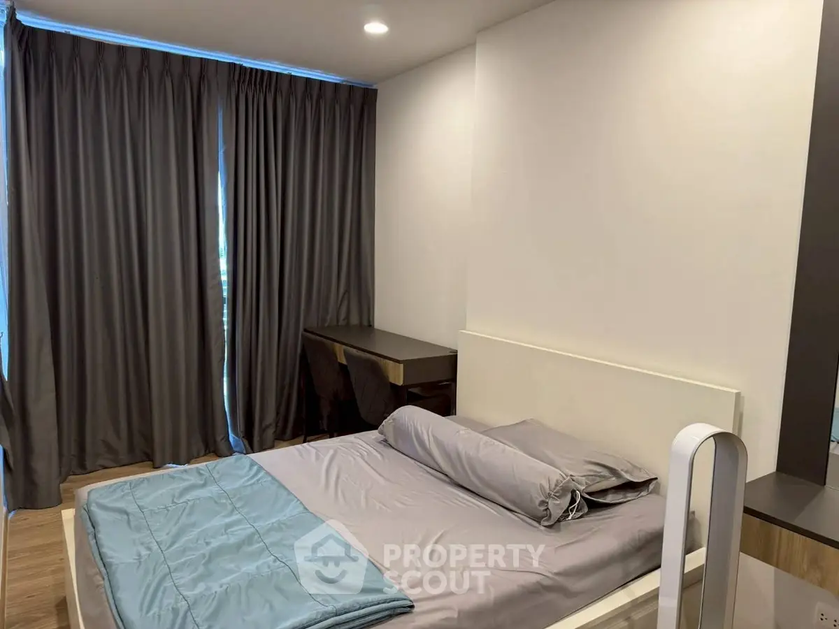 Modern bedroom with sleek design and cozy ambiance, featuring a stylish bed and elegant curtains.