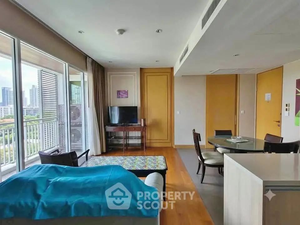 Spacious living room with modern decor and city view, featuring a cozy seating area and dining space.
