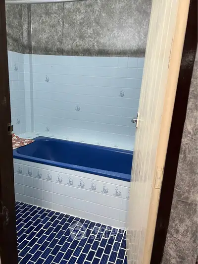 Charming blue-tiled bathroom with unique bathtub design.