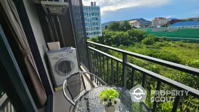 Charming balcony with scenic view and compact laundry area in modern apartment