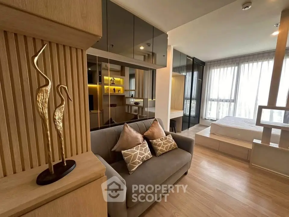 Modern studio apartment with stylish decor and open layout, featuring cozy living area and elegant bedroom.