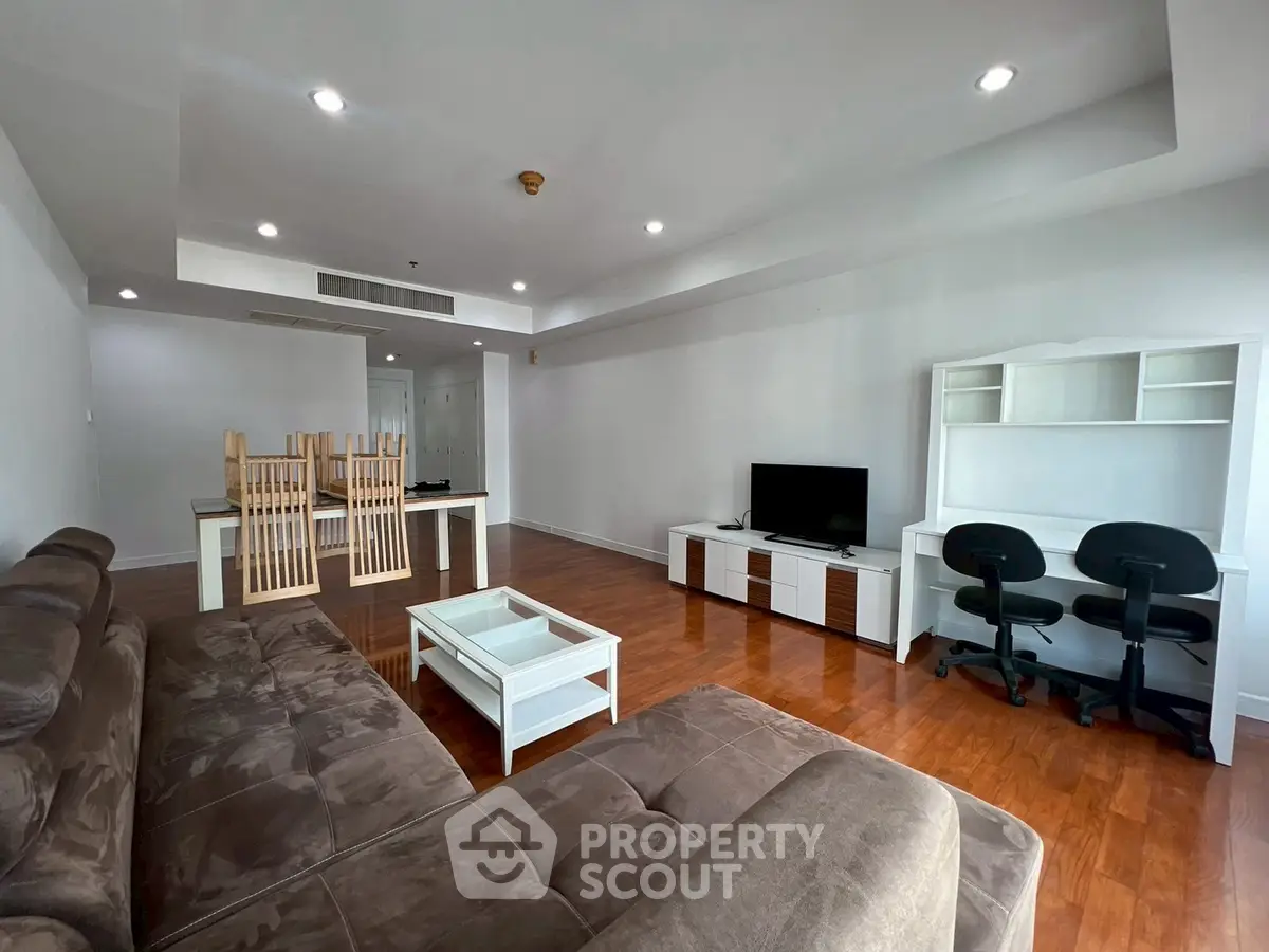 Spacious living room with modern furniture and wooden flooring, ideal for family gatherings.