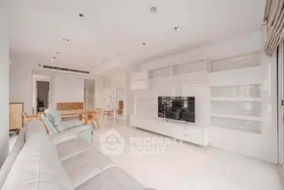 Spacious modern living room with sleek white furniture and open layout, perfect for entertaining.