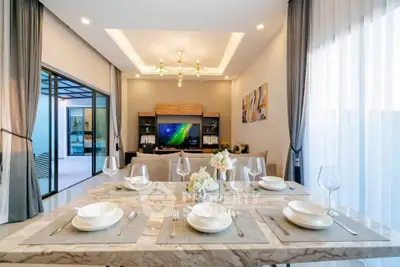 Luxurious dining area with elegant table setting and modern living room view
