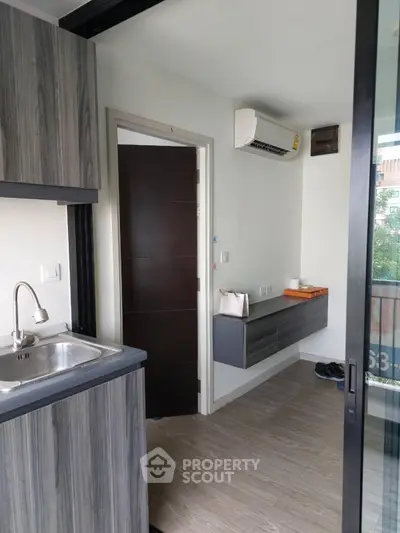 Modern apartment interior with sleek kitchen and balcony view