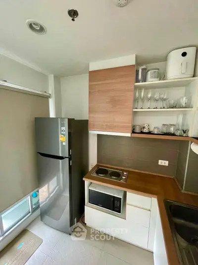 Modern kitchen with sleek appliances and stylish cabinetry in a compact layout.