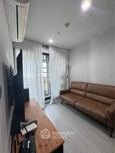 Modern living room with sleek leather sofa and large window, perfect for urban living.