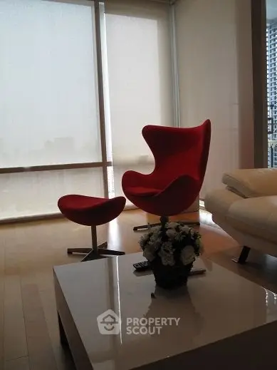 Modern living room with iconic red chair and sleek decor