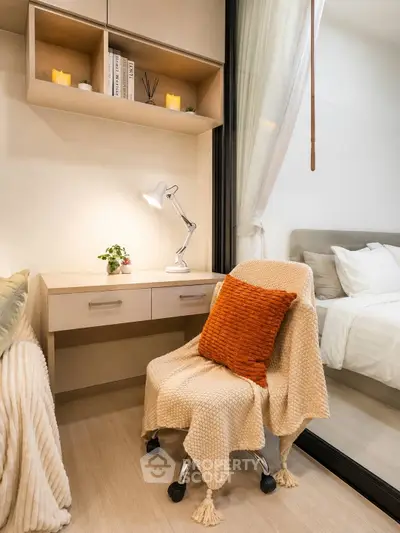 Cozy study nook with desk, chair, and warm decor adjacent to a bedroom.