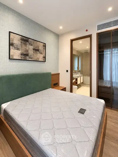 Modern bedroom with stylish decor and ensuite bathroom in a luxury apartment.