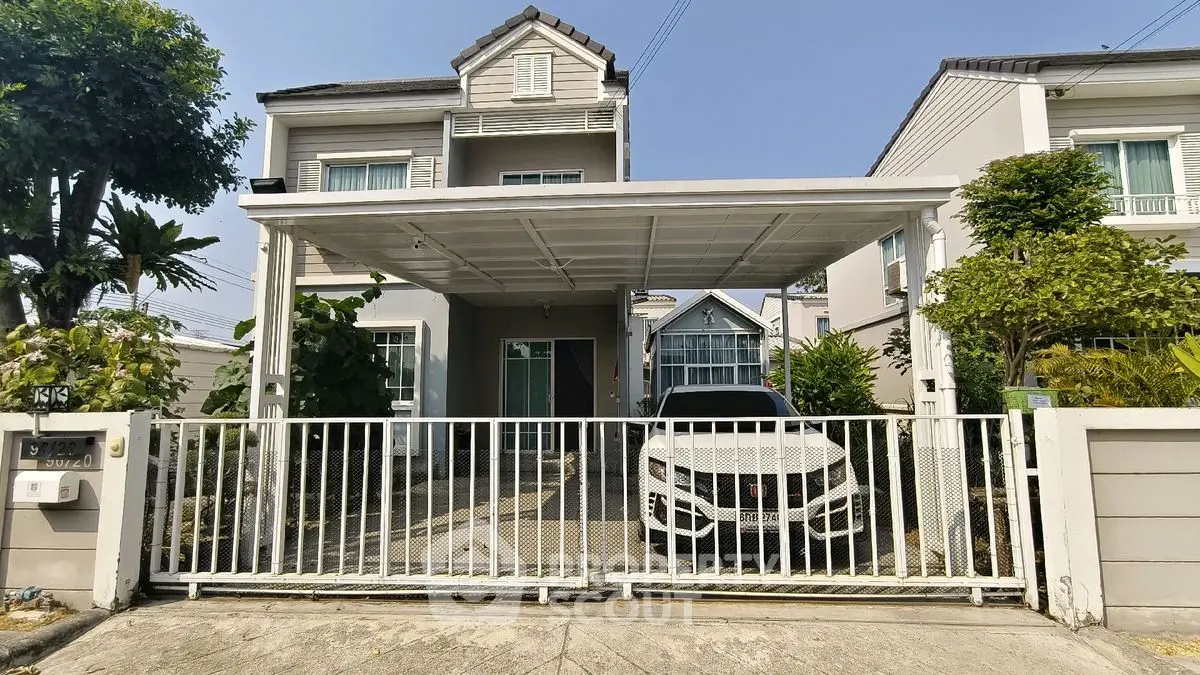 Charming two-story house with carport and gated driveway in a serene neighborhood.