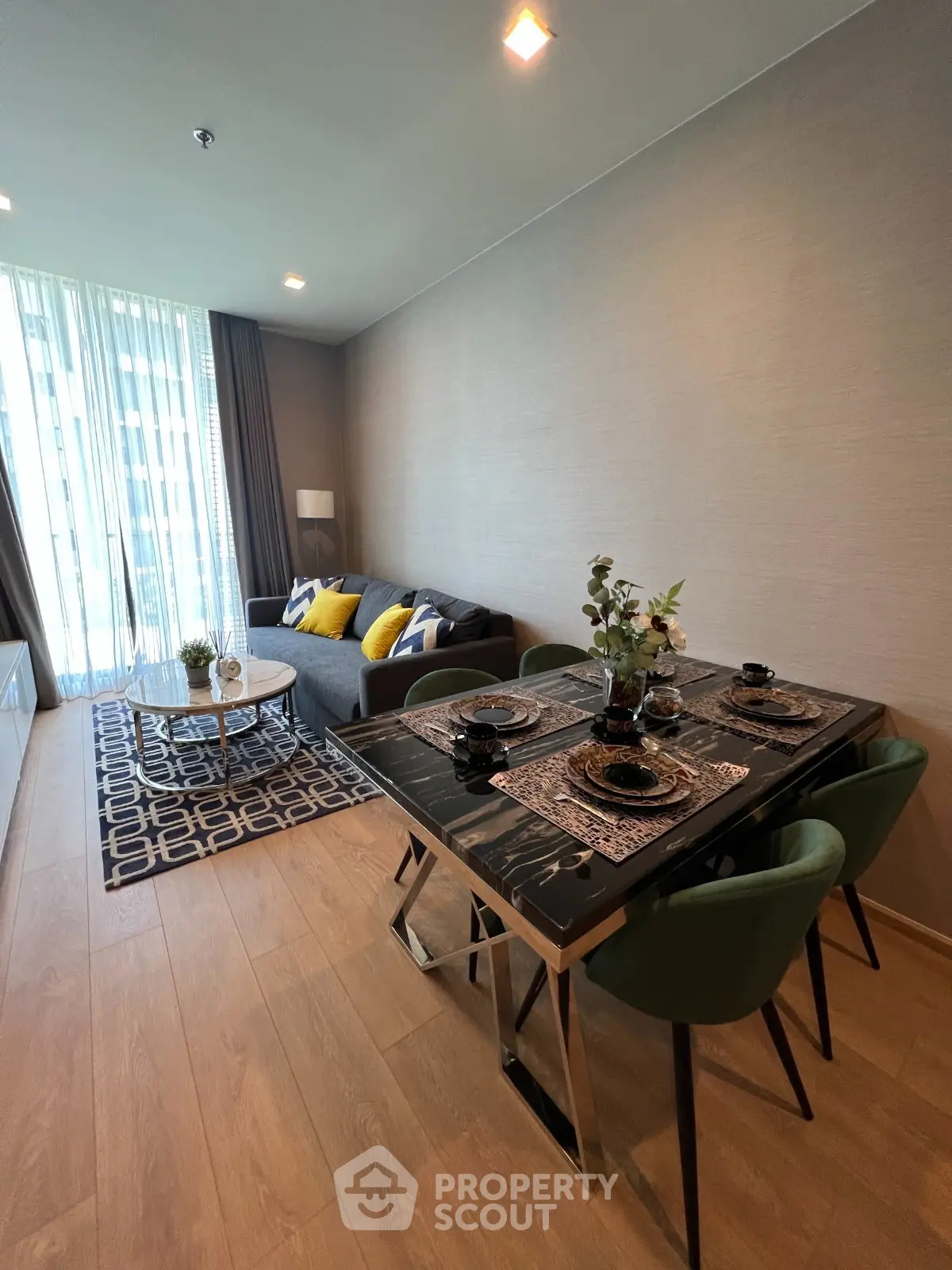 Modern living room with stylish dining area and cozy seating, featuring elegant decor and natural light.