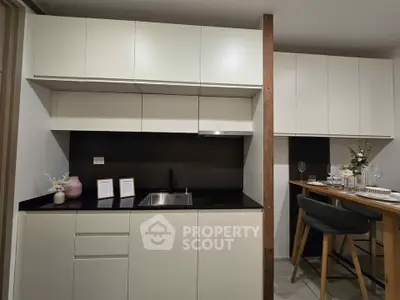 Modern kitchen with sleek cabinetry and dining area, perfect for contemporary living.