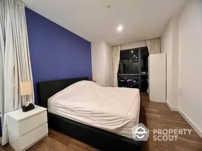 Modern bedroom with blue accent wall and large window view