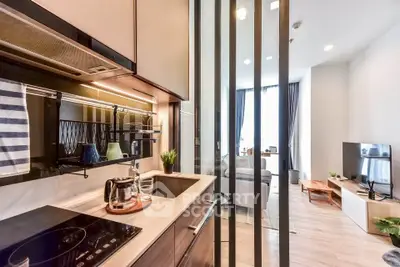 Modern open kitchen with sleek appliances and cozy living room in stylish apartment