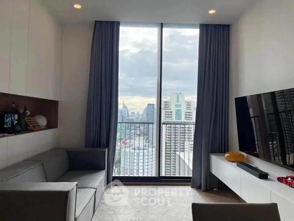 Modern living room with city view, featuring sleek furniture and floor-to-ceiling windows.