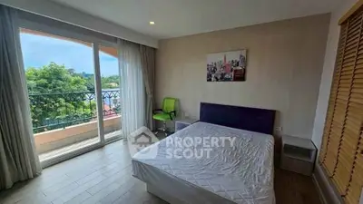 Spacious bedroom with balcony and scenic view, ideal for relaxation and comfort.