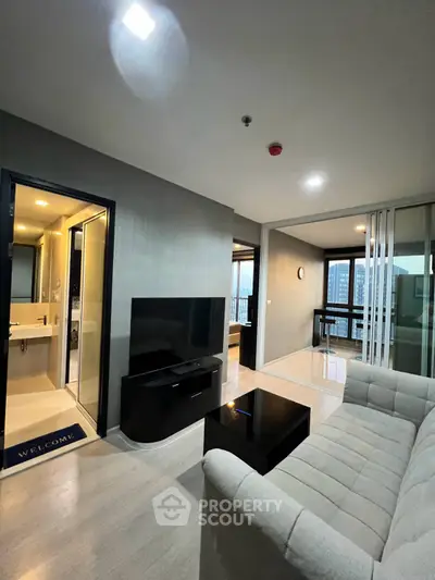 Modern living room with sleek furniture and city view balcony