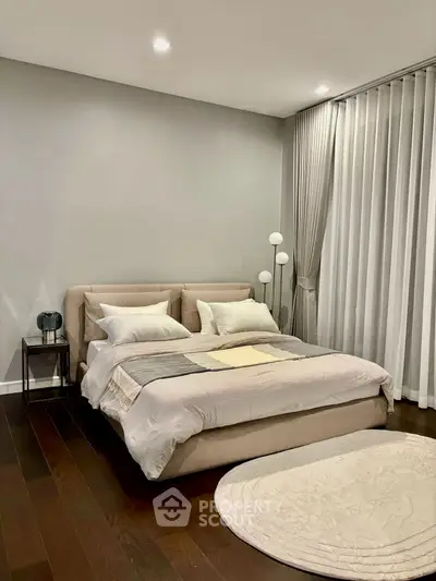 Elegant bedroom with modern decor and cozy ambiance, featuring a plush bed and stylish lighting.