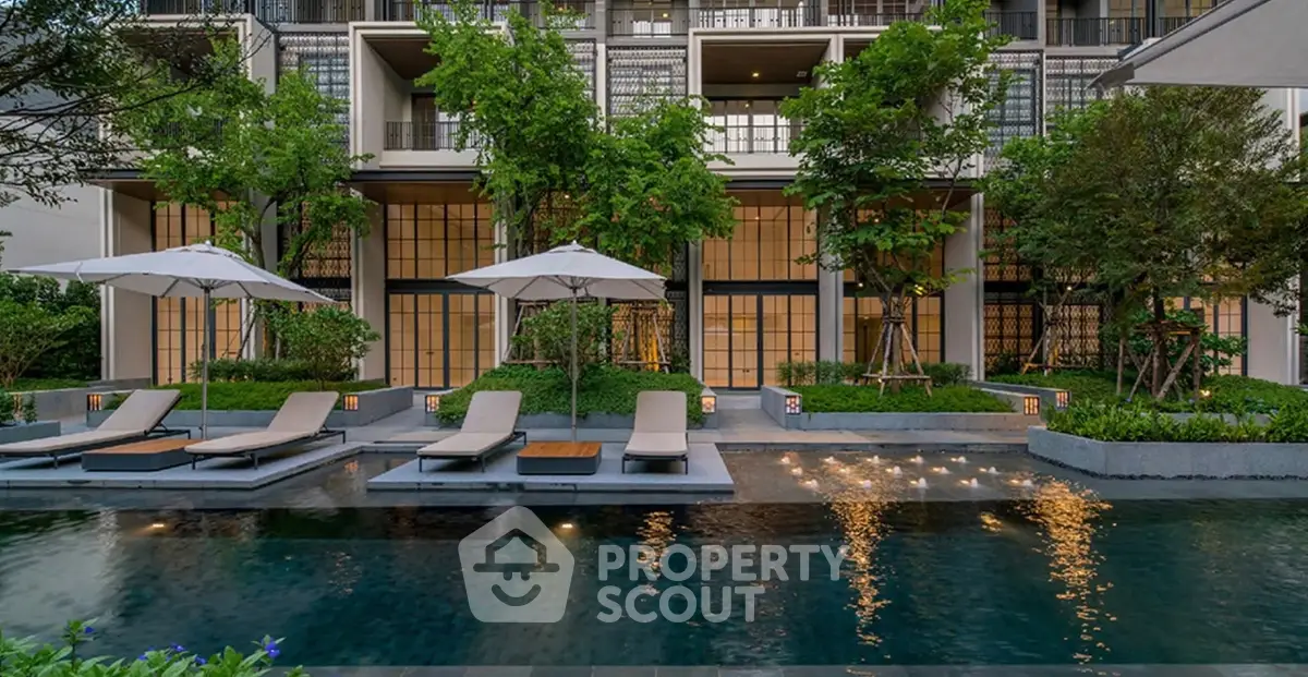 Luxurious modern apartment complex with serene pool and lush greenery