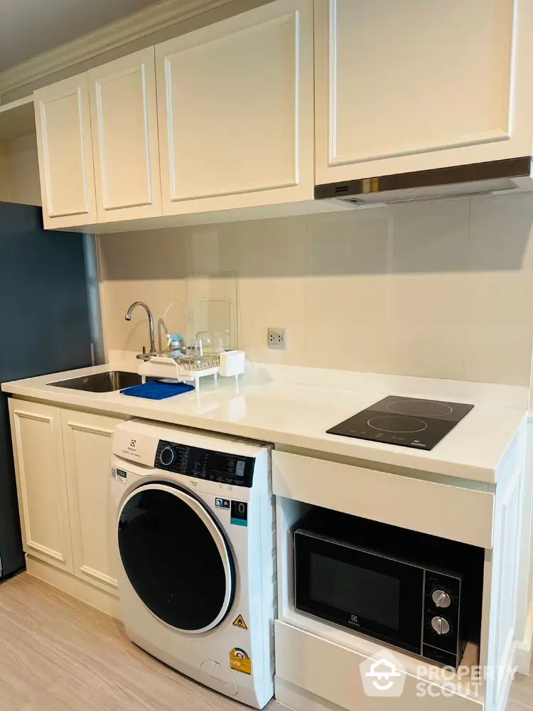 Modern compact kitchen with washing machine and microwave