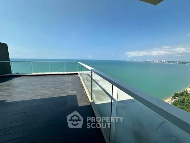 Stunning ocean view from a spacious balcony in a luxury high-rise apartment.