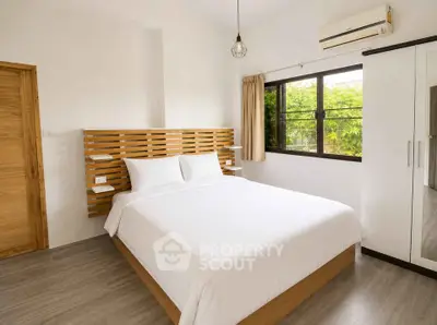 Modern bedroom with minimalist design, featuring a cozy bed and large window with garden view.
