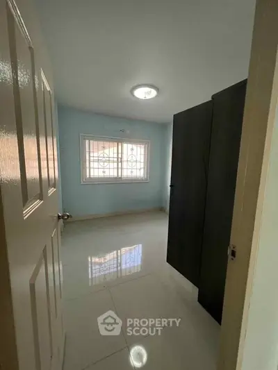 Cozy bedroom with sleek wardrobe and bright window view