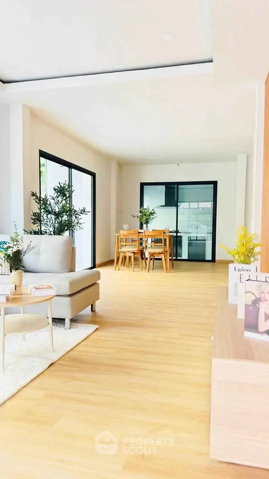 Spacious modern living room with dining area and large windows for natural light.