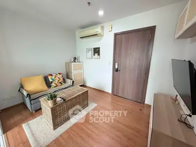 Modern living room with stylish decor and wooden flooring, featuring a cozy sofa and entertainment setup.