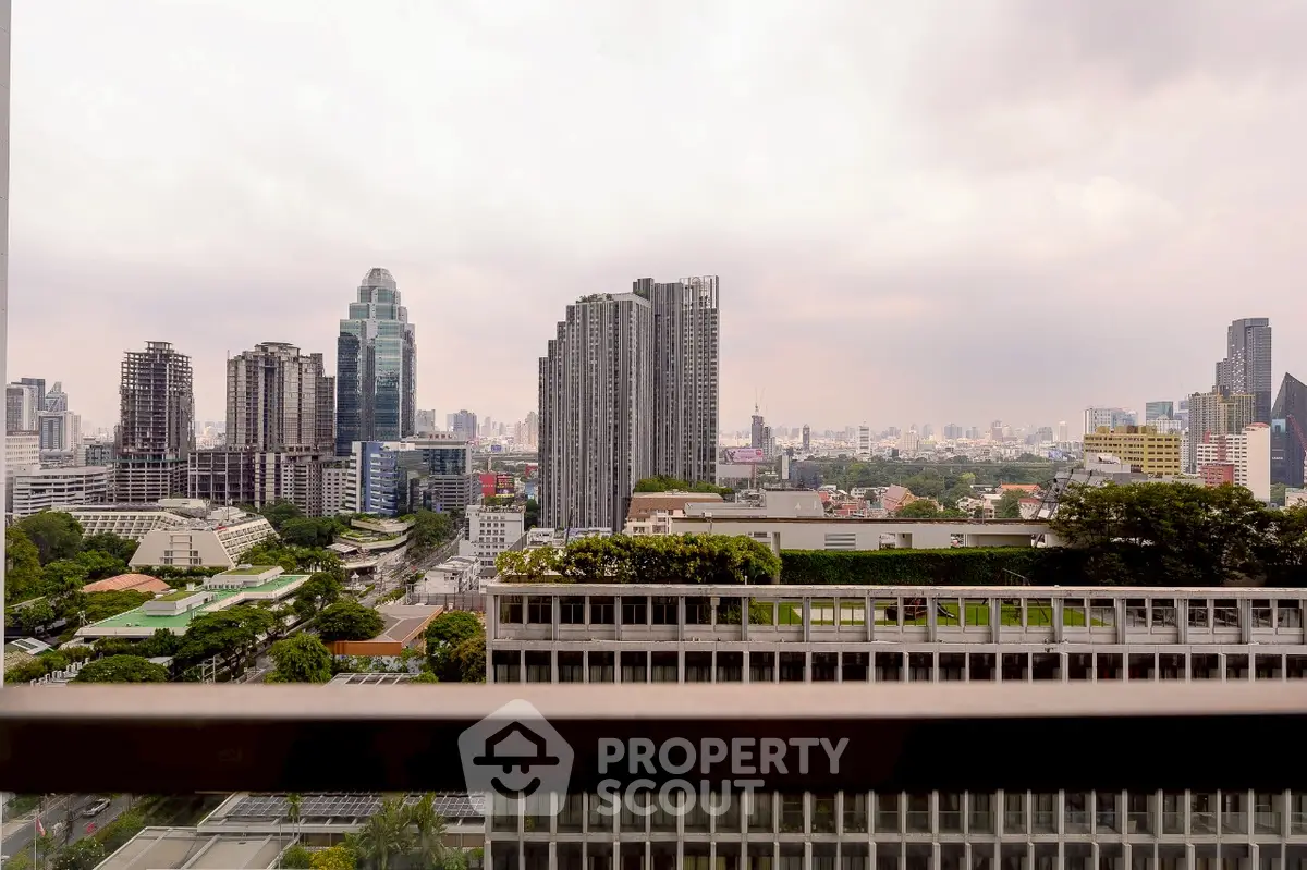 Stunning cityscape view from a high-rise balcony showcasing urban skyline and greenery.