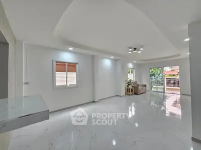 Spacious modern living room with marble flooring and balcony access