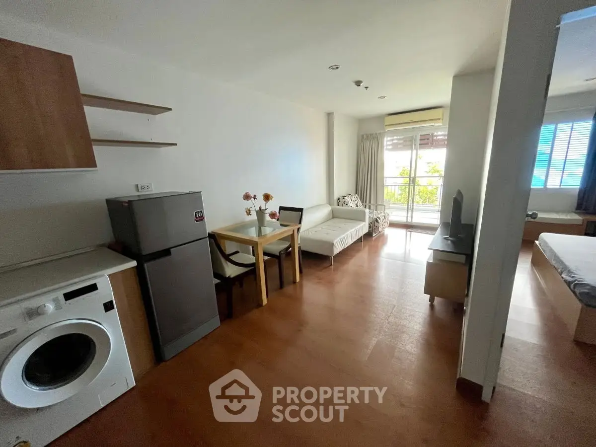 Modern studio apartment with open layout, featuring a cozy living area, compact kitchen, and bright bedroom.