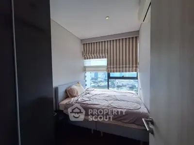 Cozy bedroom with city view and modern decor in high-rise apartment